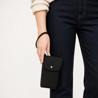 Pochette à couches noire tenue au poignet, taille réelle | NOLIERA