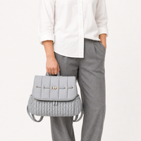 Sac à dos à langer tressé gris porté à la main, taille réelle | NOLIERA