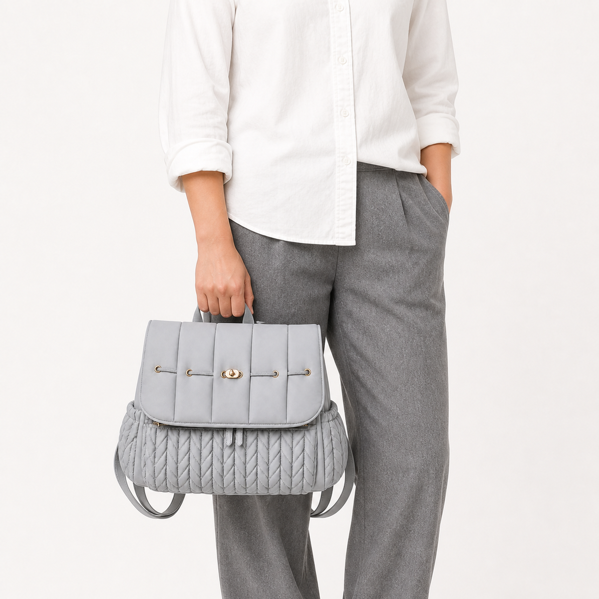 Sac à dos à langer tressé gris porté à la main, taille réelle | NOLIERA