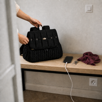 Sac à dos à langer tressé noir posé dans une entrée | NOLIERA