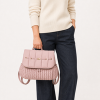 Sac à dos à langer tressé rose porté à la main, taille réelle | NOLIERA