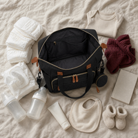 Sac à langer bandoulière noir et tout ce qu'il contient pour une journée | NOLIERA