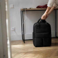 Sac à dos à langer noir posé dans une entrée | NOLIERA