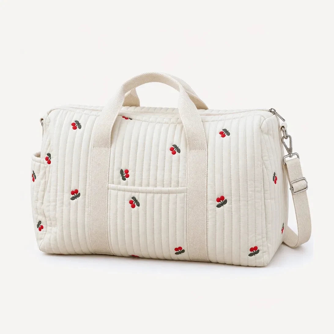 Sac de maternité matelassé écru brodé de cerises rouges, vue de trois quarts