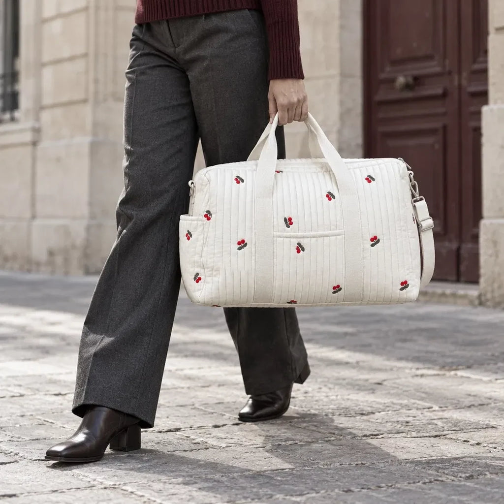 Sac de maternité matelassé motif Cerise tenu à la main en ville