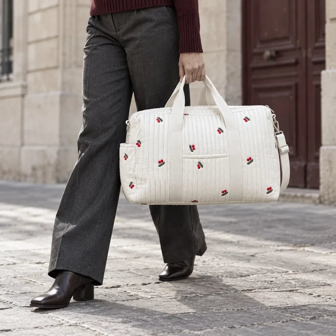 Sac de maternité matelassé motif Cerise tenu à la main en ville